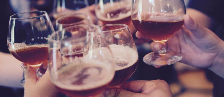 A group of six people making a toast with beer.